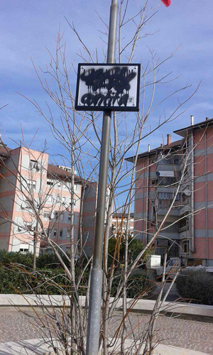 targa imbrattata con scritta Largo Martiri delle Foibe