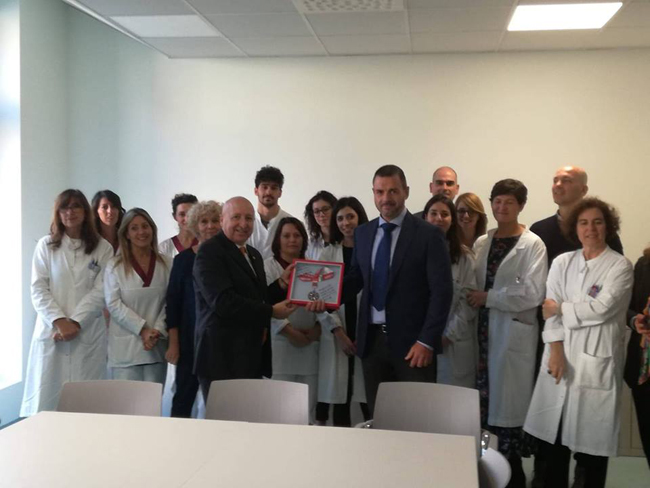 Ail, Antonio Oro, a destra, consegna la medaglia ai ricercatori